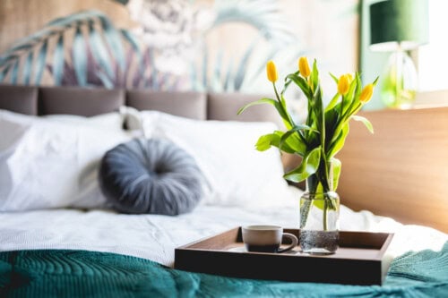 tray with flowers and cup on a bed – home staging tips