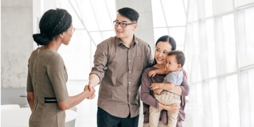 family shaking hands with real estate agent