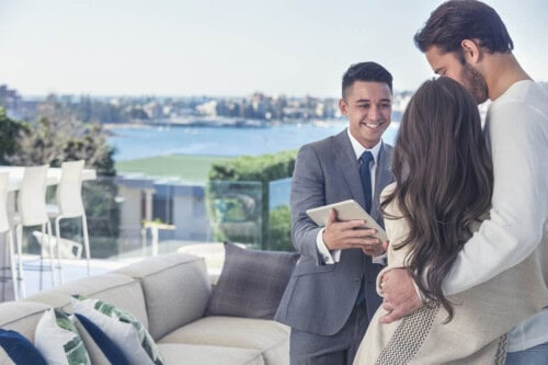 luxury real estate agent shows a home to a couple